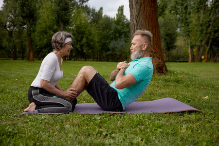 Happy married couple of retirees doing training workout in parkの写真素材