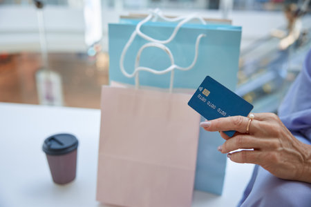 Closeup senior female hand holding credit card for shopping paymentの写真素材
