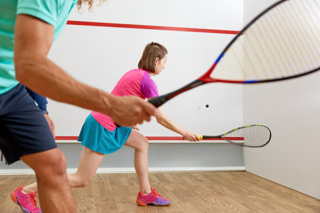 People playing squash enjoying recreational pursuit at indoor training clubの写真素材