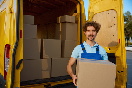 Deliveryman carrying cardboard box with purchased items in hand