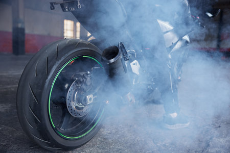 Motorcyclist squeezing clutch to start training race at motordromeの写真素材