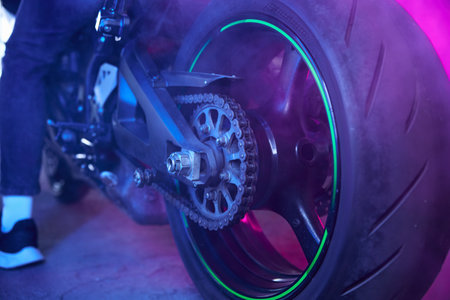 Sport motorcycle wheel view from back in neon light and smokeの写真素材