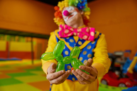 Cute green balloon dog toy in hand of funny clownの写真素材