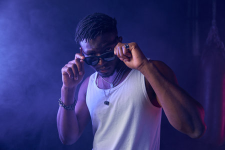 Young guy rapper posing for camera in neon light