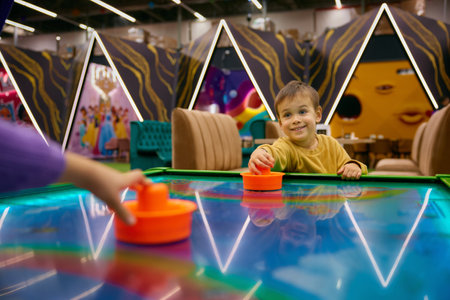 Little boy child playing air hockey at entertainment centerの写真素材