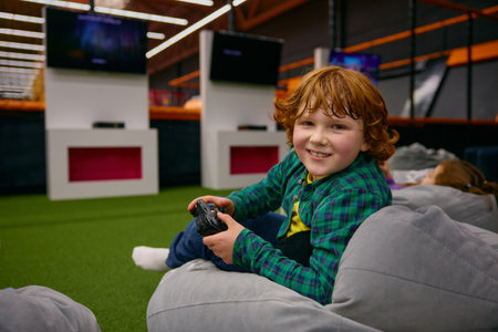 Portrait of happy boy child playing video game in kids center