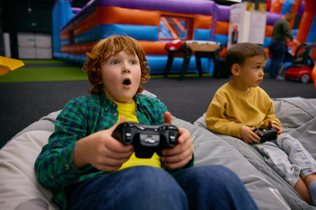 Portrait of excited boy with surprise and joy on face playing video game