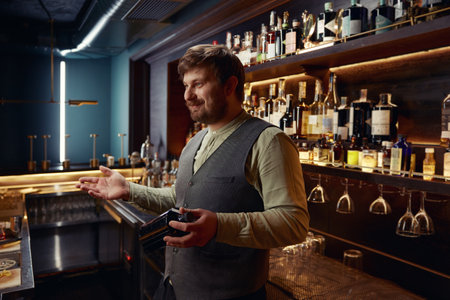 Portrait of bartender offering client to choose alcoholic drink