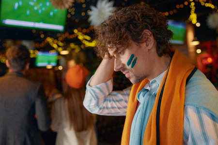 Frustrated sad man football fan touching head due to loss of favorite teamの写真素材