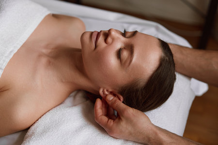 Peaceful female face at massage session in spa centerの写真素材