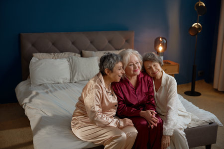 Portrait of aged female friends on pension gathering for hen-party at homeの写真素材