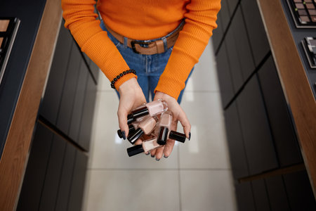 Woman holding nail polish in cosmetics storeの写真素材