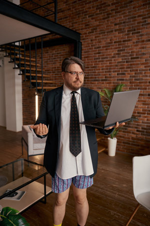 Funny businessman in formal suit and underwear giving self presentation onlineの写真素材