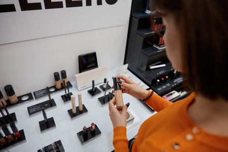 Client woman testing foundation cream in cosmetics store