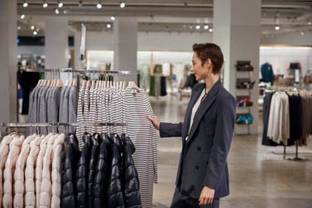Cute businesswoman doing shopping at clothing department storeの写真素材