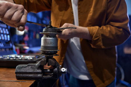 Mechanic disassembling and servicing bicycle internal-geared hub on viceの写真素材