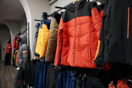 Winter sports outwear hanging coat hangers on clothing rack at shopの写真素材