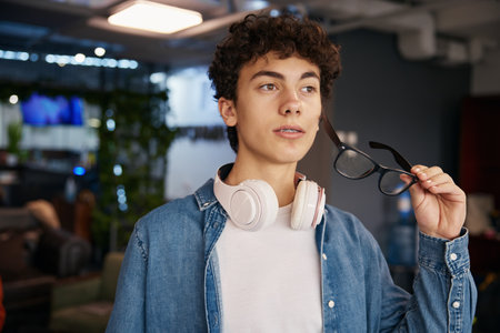 Portrait of smiling teenage boy standing in office