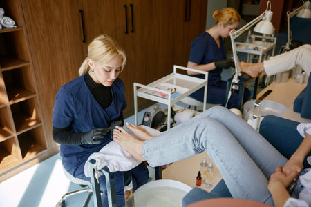 Pedicure specialist filing down toe nail plate with polishing brushの写真素材