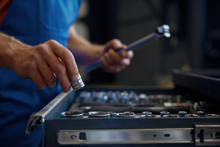 Tool box and male mechanic hands taking wrench for workの写真素材