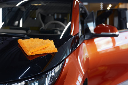Microfiber towel cloth on shiny glossy surface of polished carの写真素材