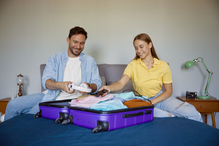 Joyful married couple planning vacation preparing clothes for travel