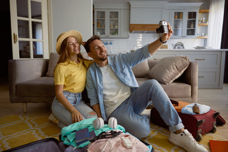 Happy loving couple taking photo during preparation for summer vacationの写真素材