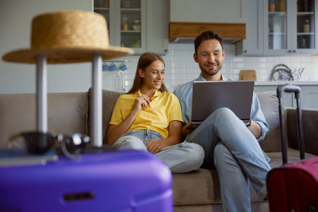 Happy loving couple planning honeymoon tour searching flight ticket on internetの写真素材
