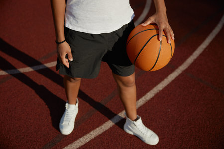 Basketball ball in hand of young girl playerの写真素材