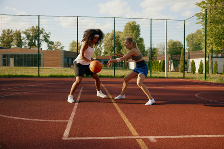 Two girl basketball players enjoying competitive game at outdoor courtの写真素材