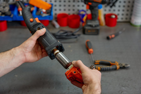 Male repairman fixing electrical angle grinder by replacing motor