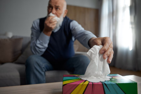 Selective focus on senior man hand taking napkin from box holderの写真素材
