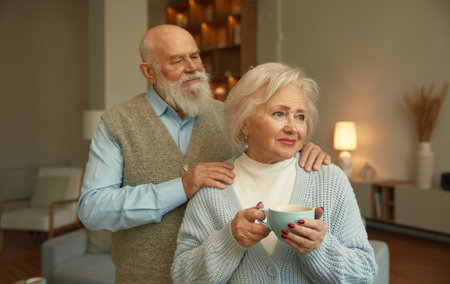 Loving senior couple together over home living room interiorの写真素材