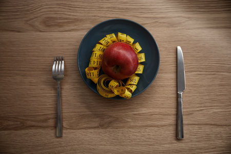 Fresh raw apple fruit with measuring tape on plate tablewareの写真素材