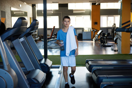 Teenager boy preparing for cardio training workout at sport centerの写真素材