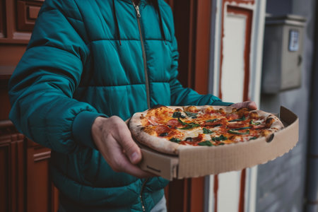 Closeup of delivery man handing over pizza at a doorstep, residential area. Generative AIの素材