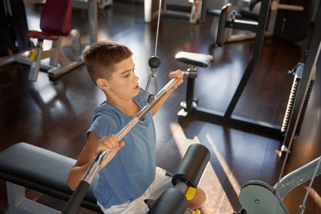 Inspired teenage boy enjoying training on modern gym sports equipmentの写真素材