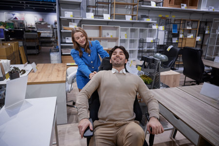 Two people relax in stylish office furniture showroom showcasing modern designsの写真素材