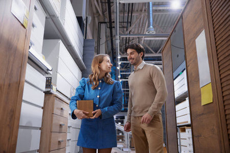 In a modern storage space, a woman and a man chat, highlighting collaboration and innovative designの写真素材