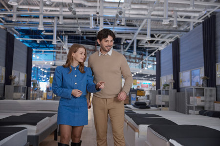 A couple is shopping for furniture in a contemporary showroom, exploring optionsの写真素材