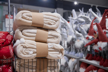 A neatly arranged stack of blankets stored in a basket within a storeの写真素材