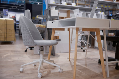 A chair placed right next to a desk inside a storeの写真素材