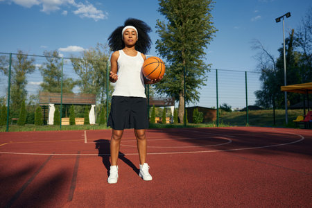 Attractive teenage girl athlete posing over basketball courtの写真素材