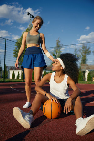 Two attractive multicultural female basketball player taking restの写真素材