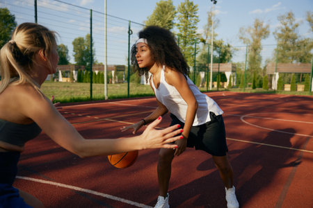 Athlete girls playing basketball together at outdoor courtの写真素材
