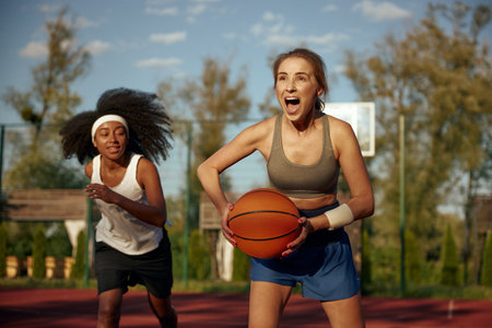 Young woman basketball players running with ball ready to pass into basketの写真素材
