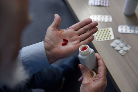 Medical pills tablets and capsules in senior man hand