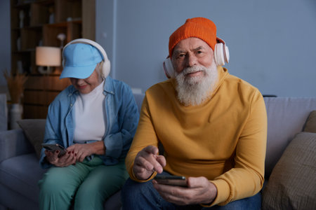 Trendy fashion senior couple using modern gadgets for fun and relaxの写真素材