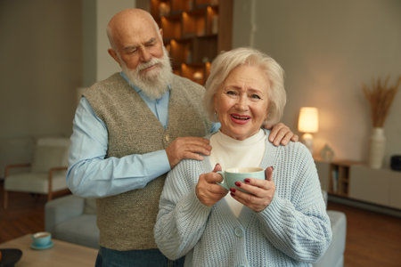Portrait of loving senior couple together over home living room interiorの写真素材