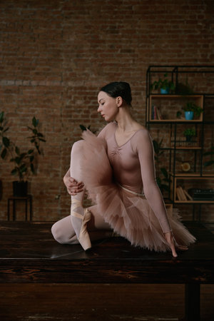An exquisite and graceful ballet dancer is posing elegantly in a contemporary artistic settingの写真素材